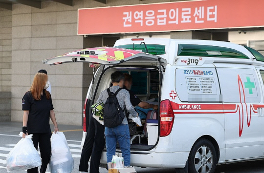 정부가 4일 군의관 등 보강 인력을 긴급 배치했다. 이날 서울 양천구 이화여자대학교 목동병원 응급의료센터 인근에서 한 환자가 이송되고 있다.<연합뉴스>